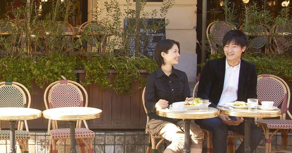 カフェのテラス席で過ごす男女